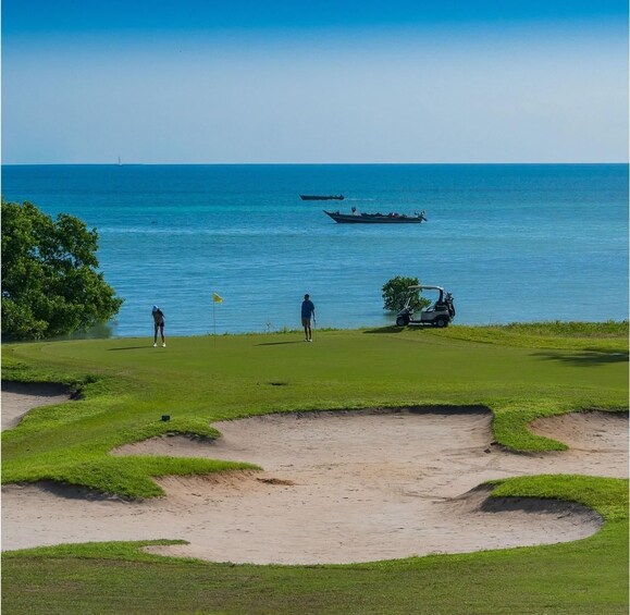 A golf course with a water body in the background. 2
