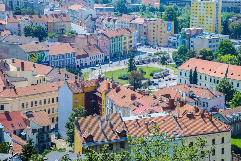 A cityscape with a mix of historic and modern buildings, a central roundabout, and a tram line. 4