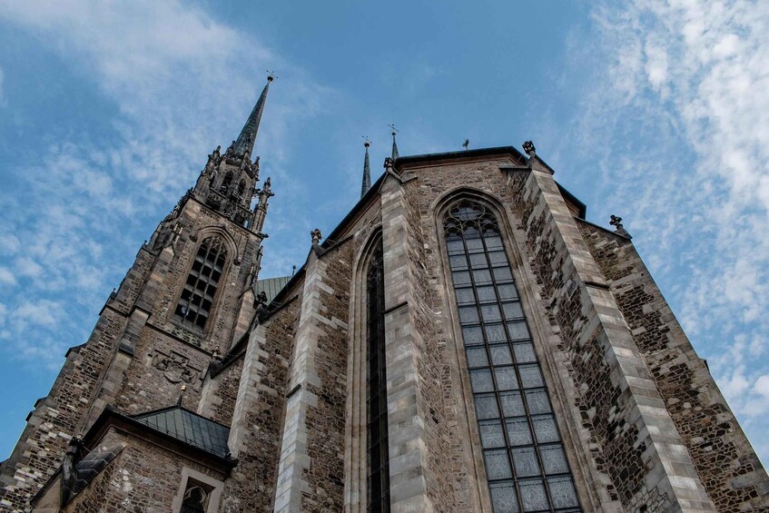 A historic church with a tall spire and large arched windows. 2