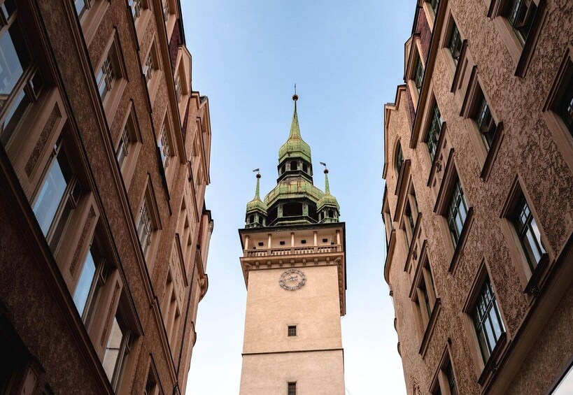 A tall tower with a clock and a green spire. 3