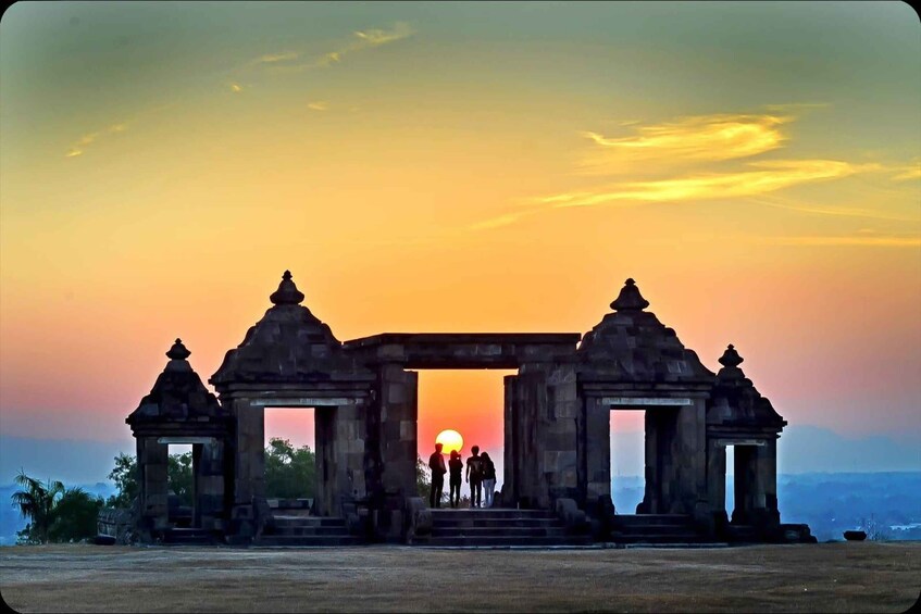 An ancient stone gateway with a sunset in the background. 3