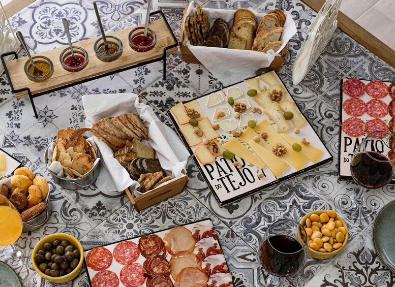 A charcuterie board with various cheeses, cured meats, nuts, and bread, accompanied by glasses of wine. 3