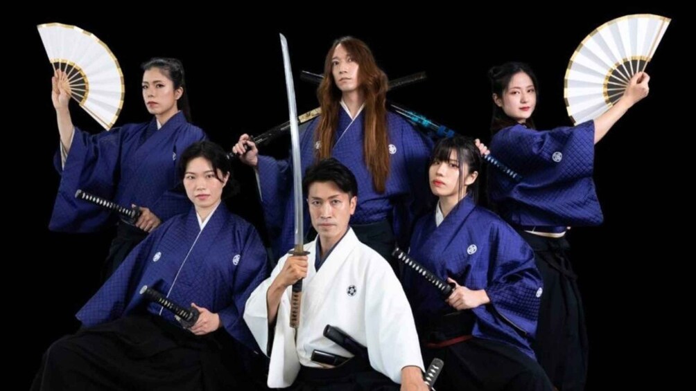 A group of people in traditional martial arts attire with swords and fans. 5