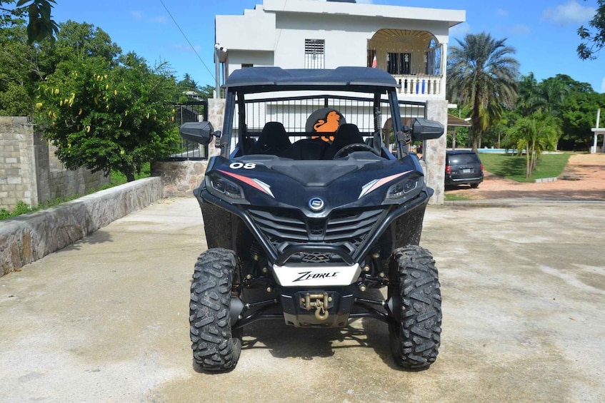 A black ATV with 'ZFOURLE' branding parked on a concrete driveway. 1