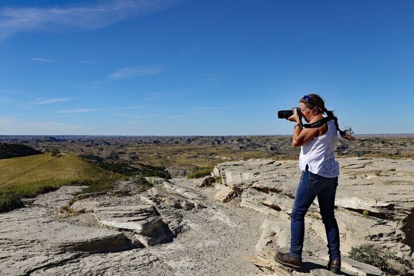 A person taking a photo with a camera in a rocky landscape. 3