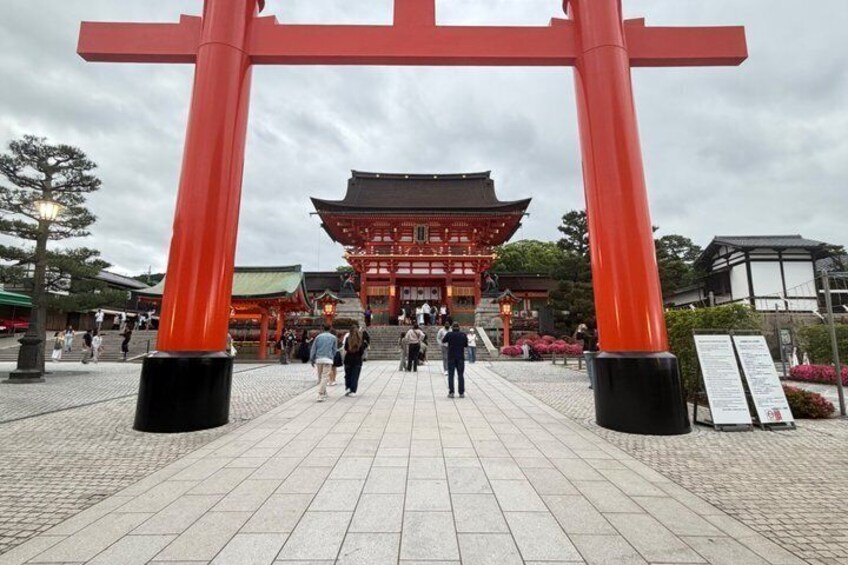 A traditional Japanese gate with red pillars and a building in the background. 4