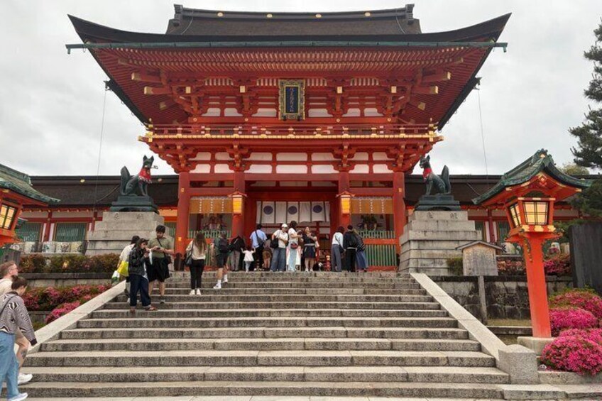 A traditional Japanese temple with a red torii gate, stone steps, and a statue of a lion-dog. 3