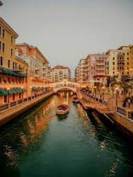 A canal with buildings on either side and a boat in the water. 2