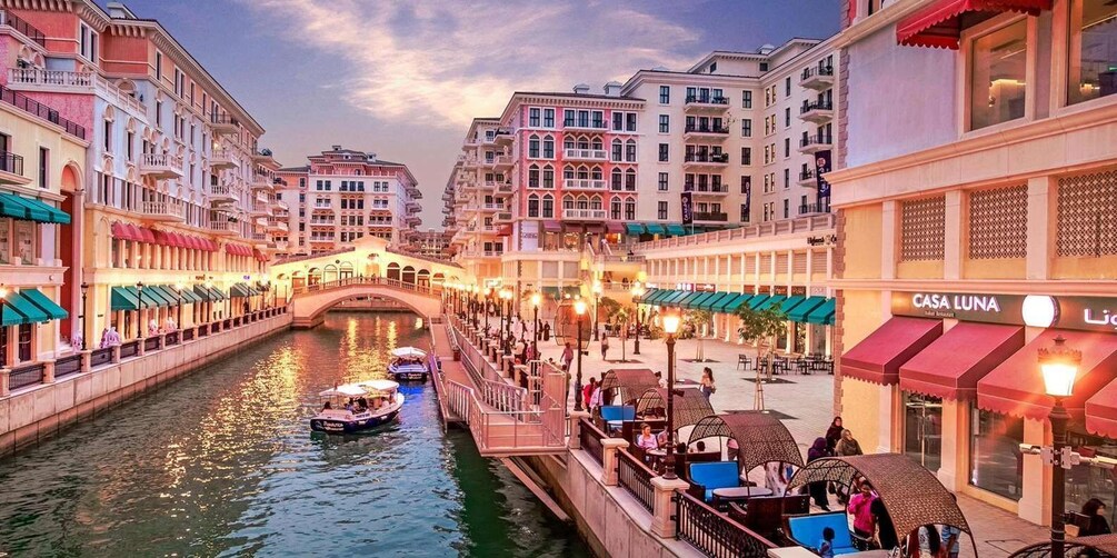 A canal with boats, a bridge, and buildings with shops and restaurants. 3