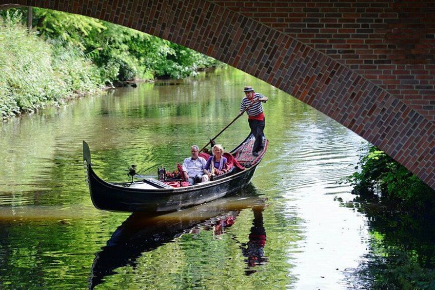 A gondola on a canal with a bridge in the background. 4