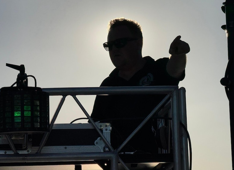 A person standing on a stage with a microphone and sound equipment. 5