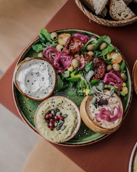A plate of food with various dips and vegetables. 2
