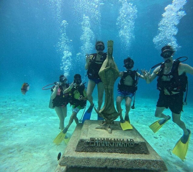 Divers around a submerged monument with the inscription 'EHANKANAAR.' 1