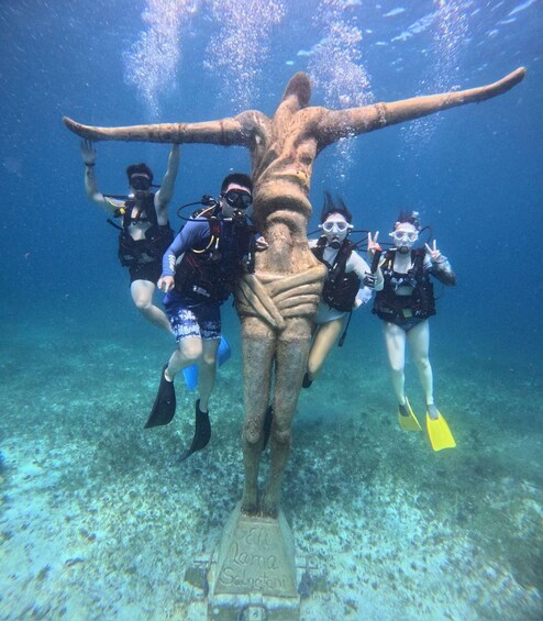 Divers interacting with a large underwater sculpture. 5