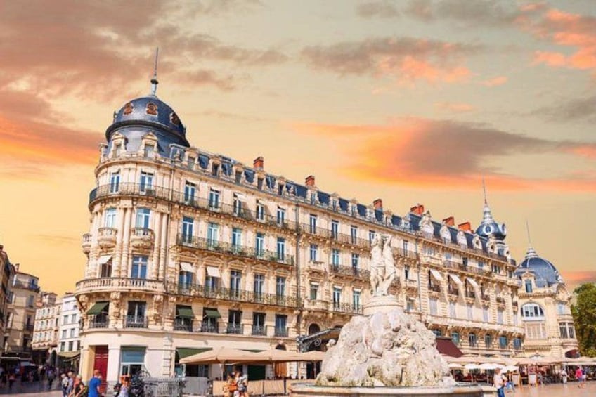 A historic building with ornate architecture, a fountain, and a sunset sky. 4