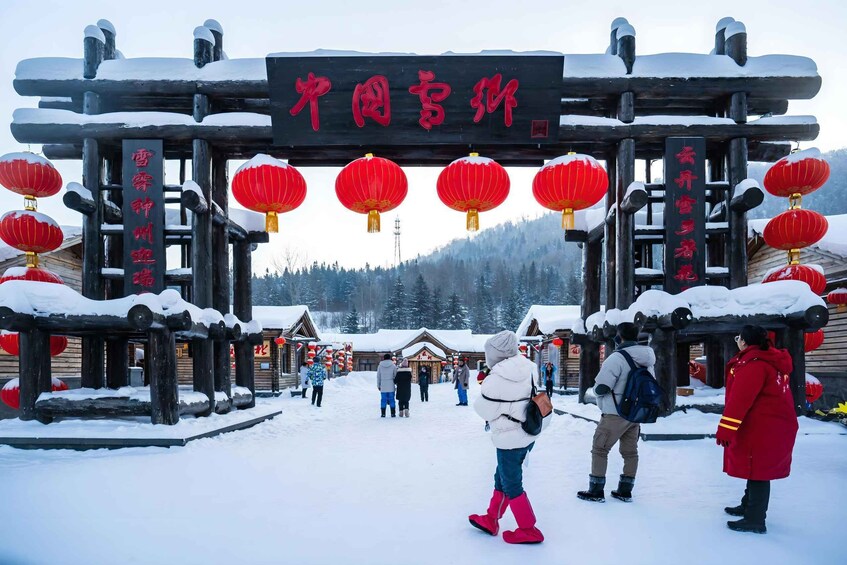 A snowy entrance with red lanterns and wooden structures. 5