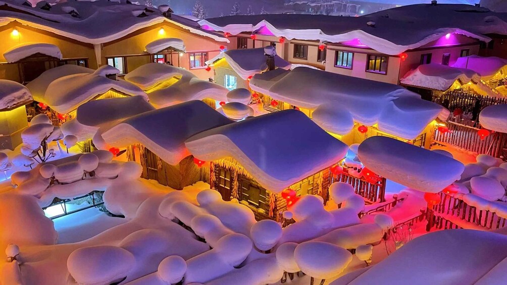 A snow-covered village with illuminated buildings and festive decorations. 3