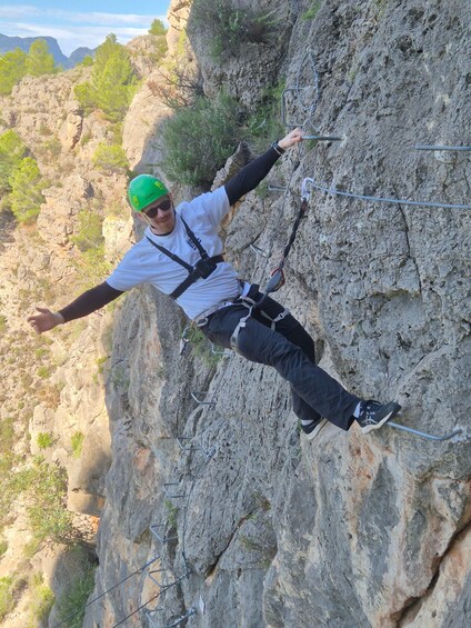 A person rappelling down a rocky cliff. 5