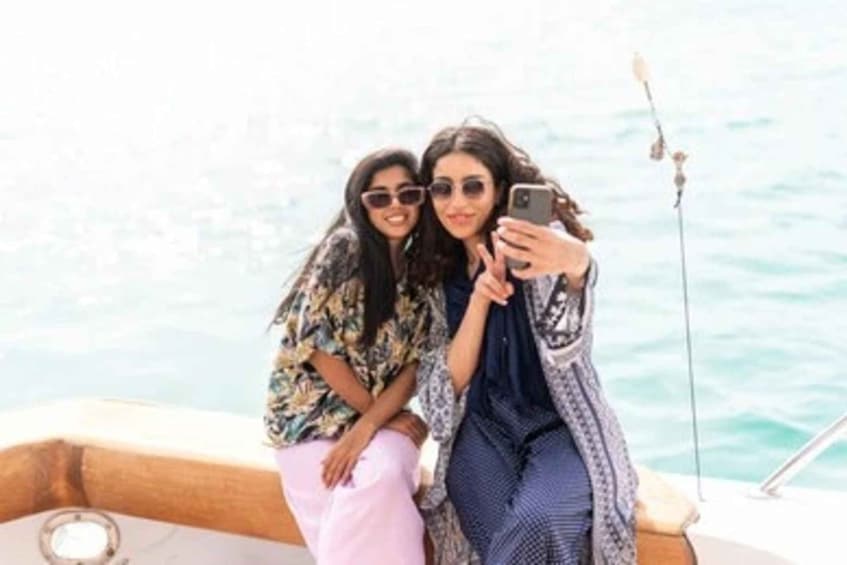 Two people on a boat, one holding a smartphone. 4