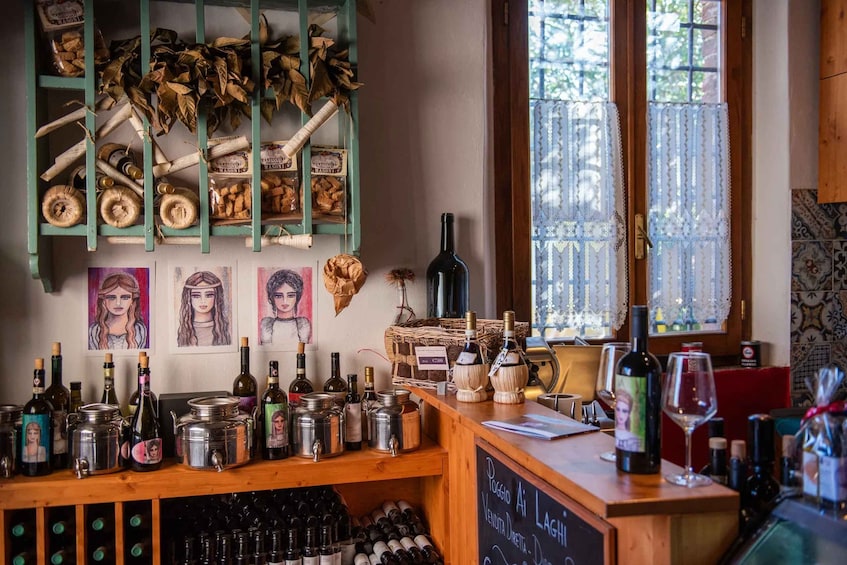A bar with wooden shelves, wine bottles, and a chalkboard menu. 2