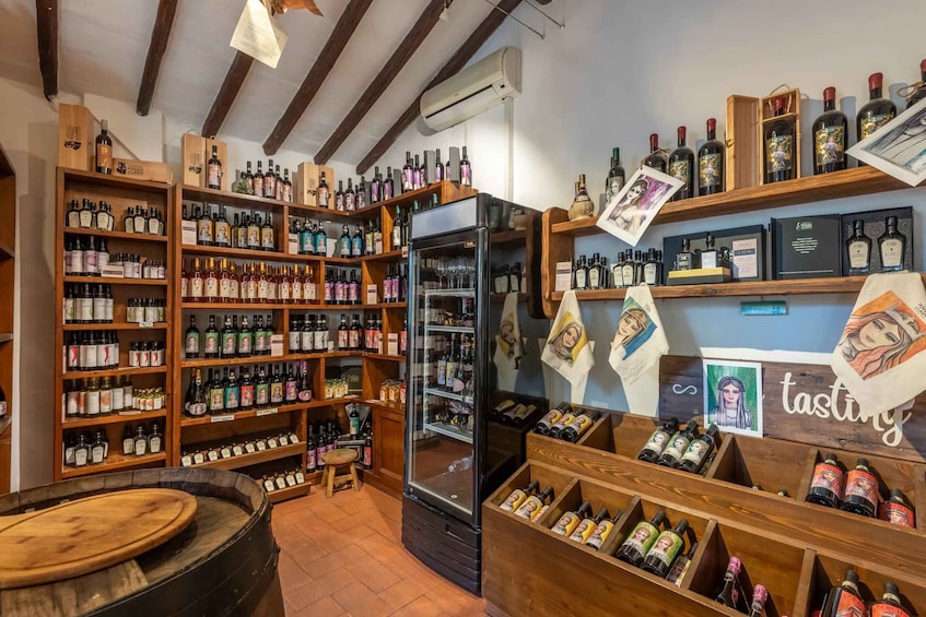 A well-stocked liquor store with wooden shelves and a large barrel. 5