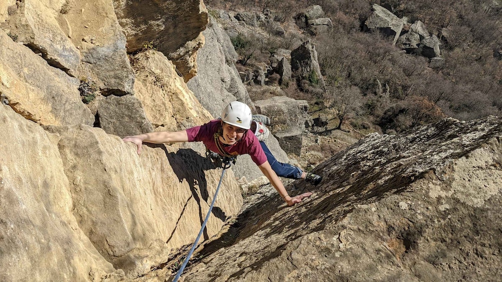 A person rock climbing on a rocky cliff. 1
