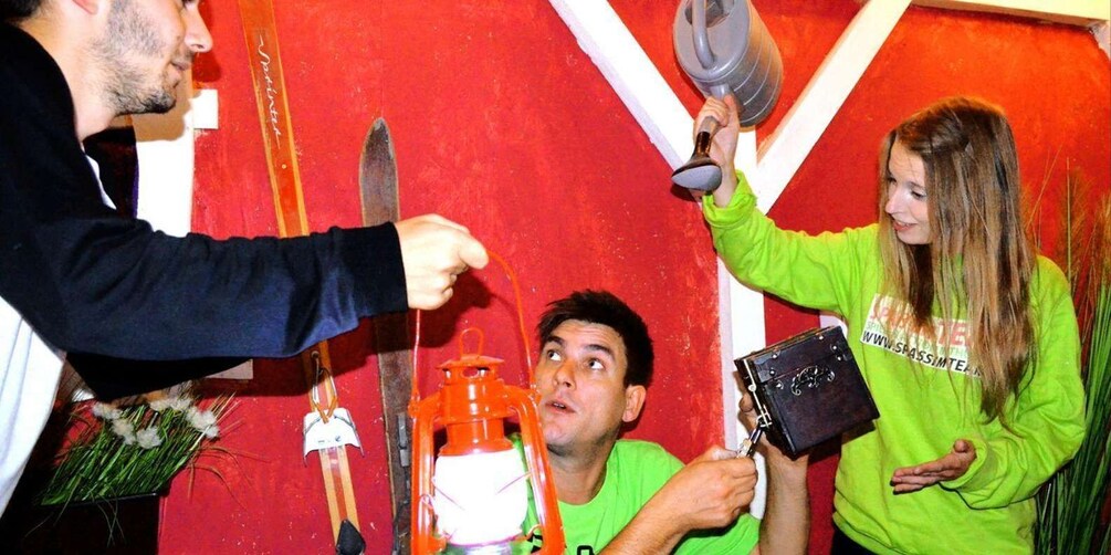 A person holding a lantern, another holding a box, and a third person with a knife. 2