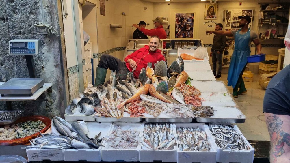 A fish market with various seafood displayed on ice and in trays. 5