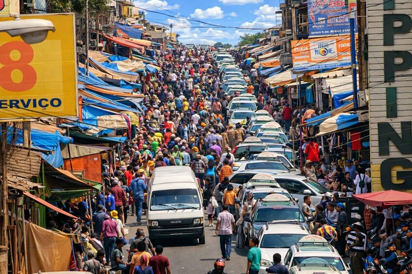 A crowded street with numerous people and vehicles. 2