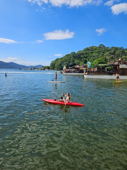 A calm lake with paddleboards, a dock, and a forested hill in the background. 5