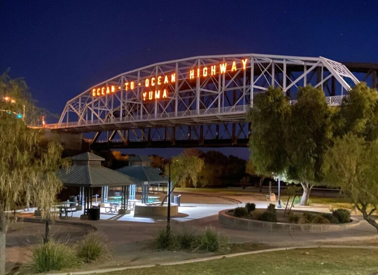 A bridge with 'OCEAN TO OCEAN HIGHWAY' illuminated signs, a gazebo, and surrounding greenery. 2