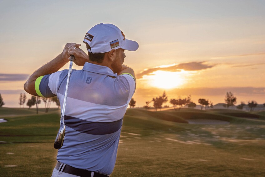 A golfer at sunset on a golf course. 3