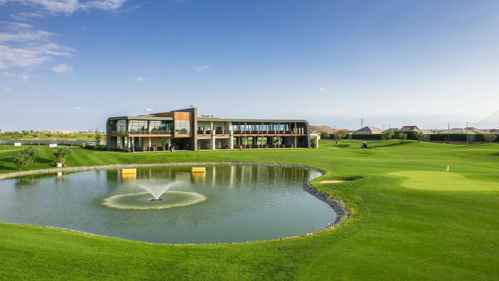 A modern building with a pond and a golf course. 5