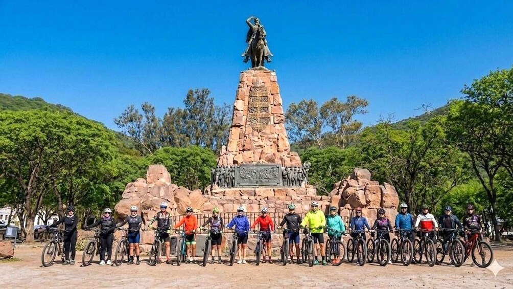 A monument with a statue on top, surrounded by a group of cyclists. 1