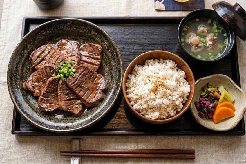 A meal with grilled meat, rice, and vegetables on a tray. 1