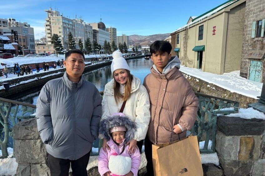 A group of people standing by a river with buildings in the background. 5