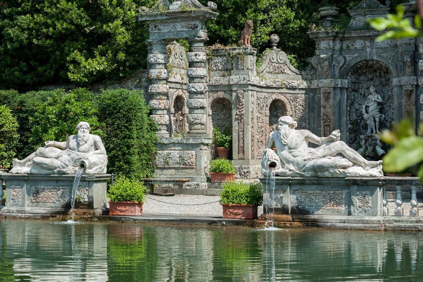 A classical garden with statues and a fountain. 3