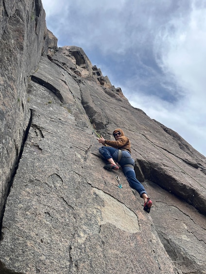 A person climbing a large rock face. 2