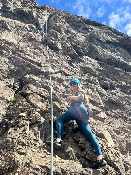 A person climbing a rocky mountain with a rope. 5
