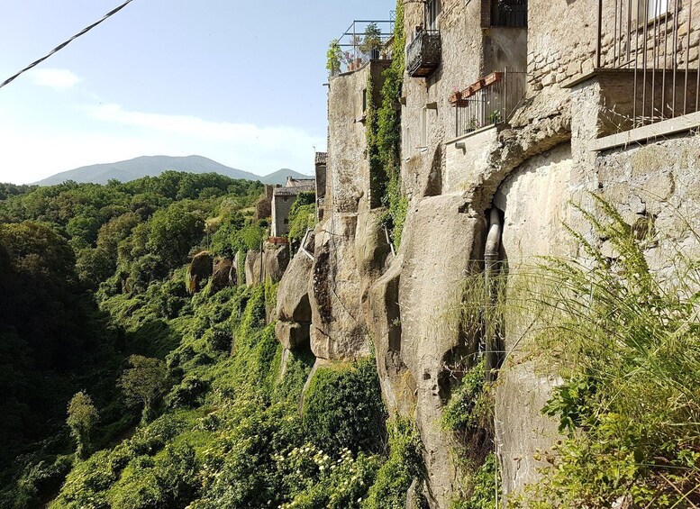 A stone tower with a balcony overlooking a lush valley. 1