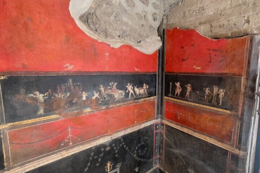 A fresco with red and black panels, depicting figures in ancient attire. 5