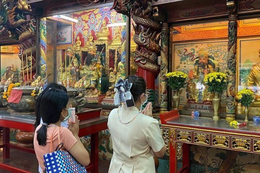 A temple interior with statues and floral arrangements. 3