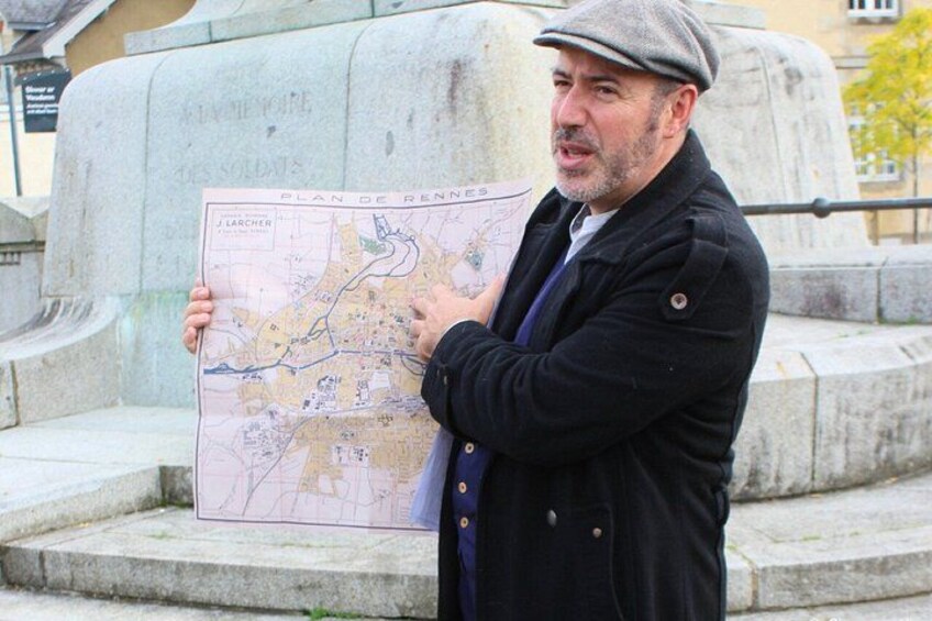A man holding a map in front of a stone monument. 3