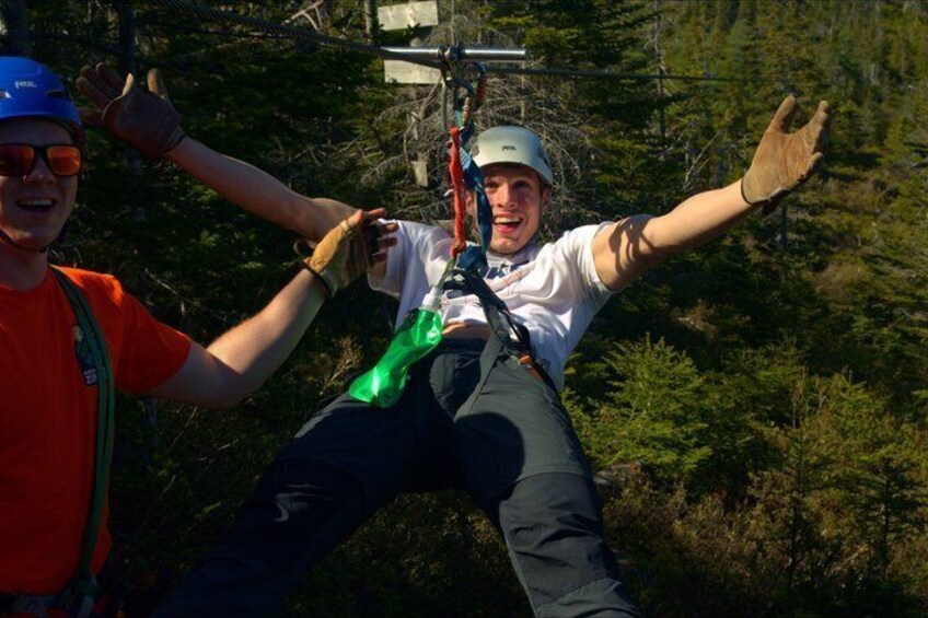 A person bungee jumping with a harness and safety gear, surrounded by dense forest. 3