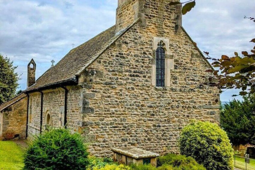A stone church with a bell tower and a small window. 4
