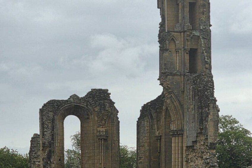 Ancient ruins with arched doorways and a tall, deteriorating tower. 2