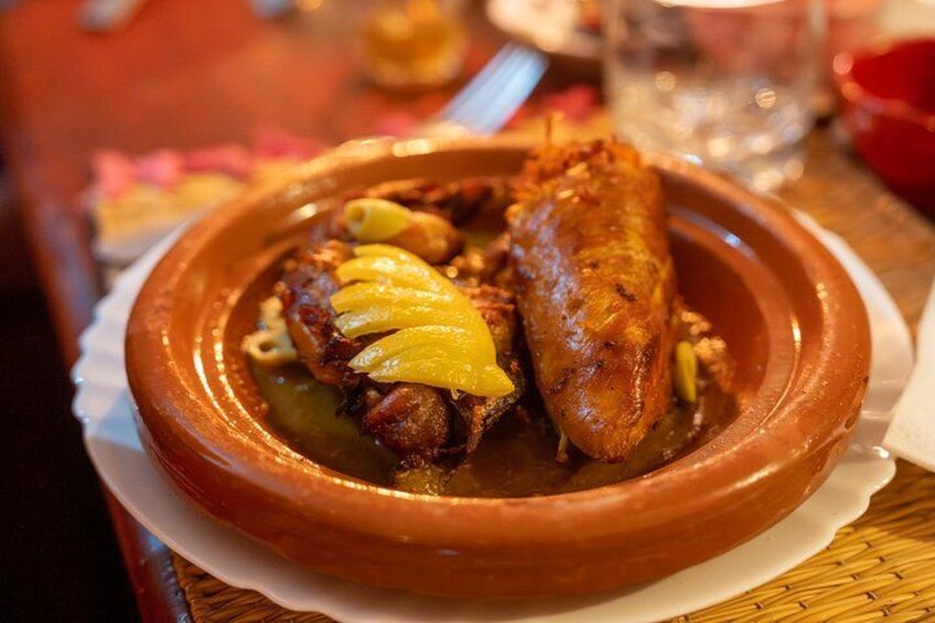 A clay pot containing a dish with meat and vegetables. 3