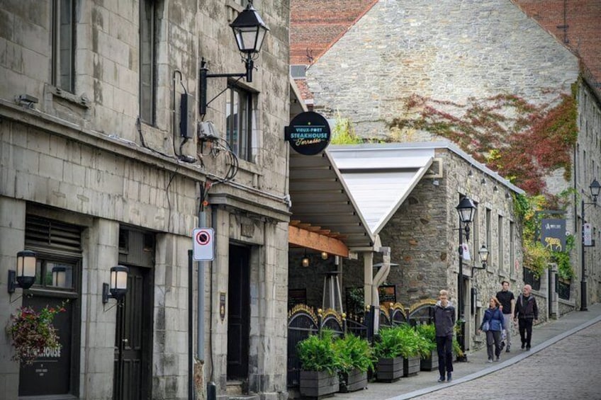 A stone building with a sign for 'The First Storehouse' and a pedestrian walkway. 4