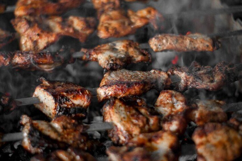 Skewered meat grilling over an open flame. 3