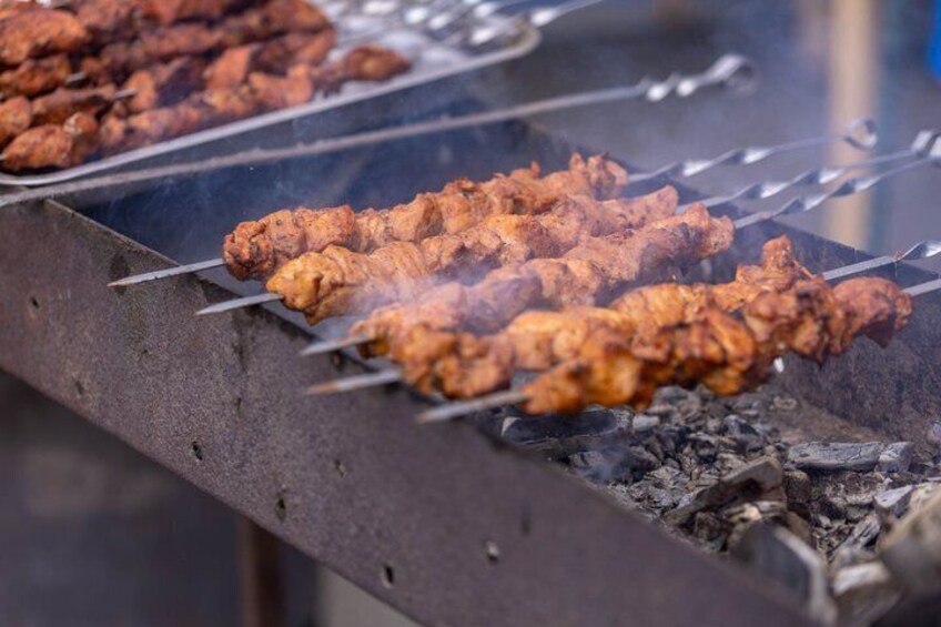 Skewers of meat being grilled over charcoal. 4